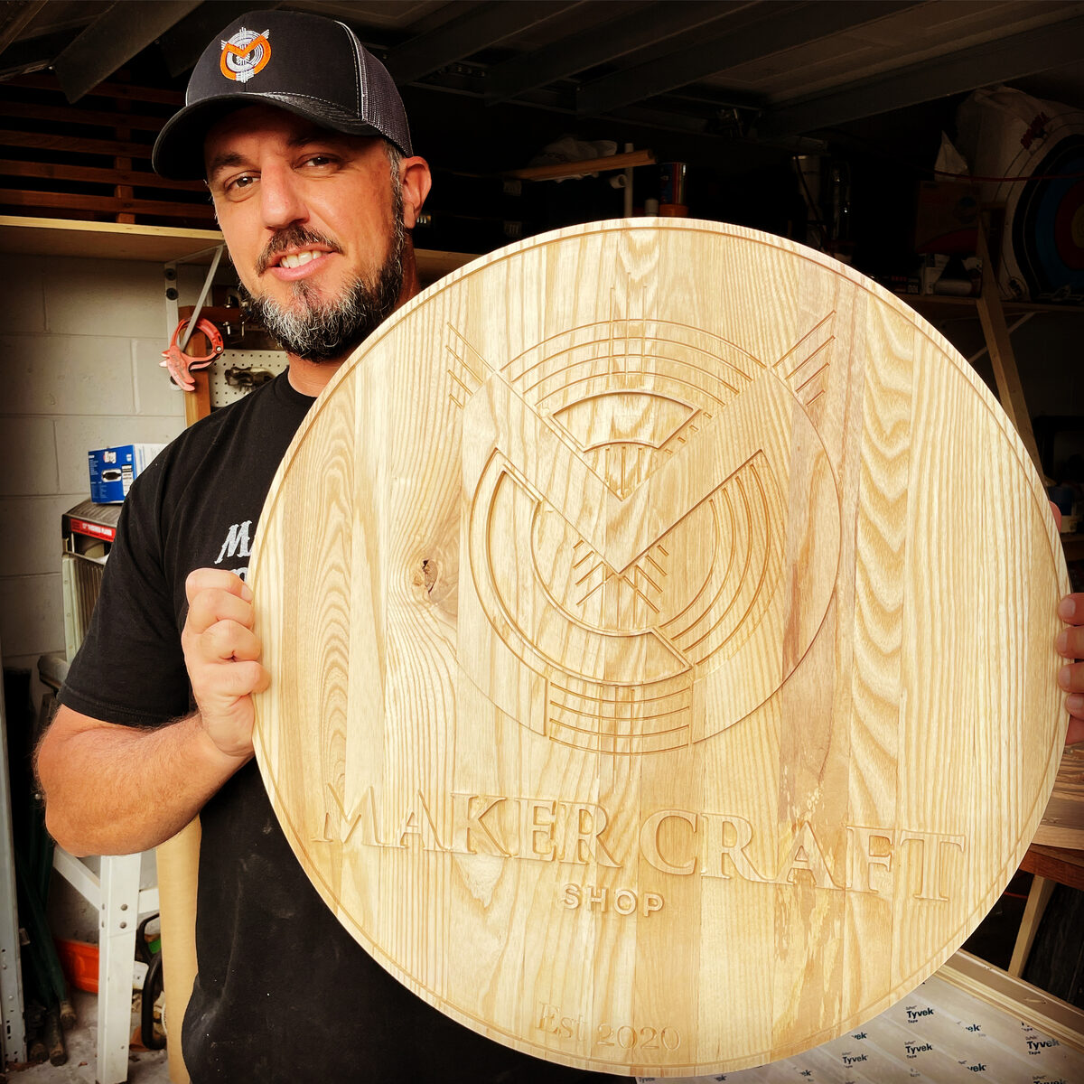 Damon Abruzere holding CNC-carved MakerCraft sign